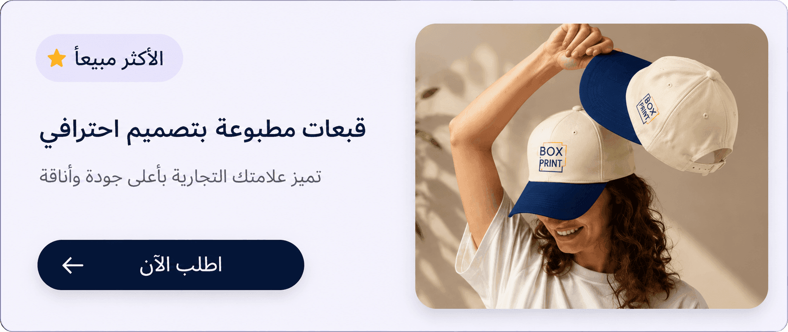لوحة إعلانية بالعربية لقبعات مطبوعة، تعرض شخصاً يحمل قبعتين تحملان شعار بوكس برنت